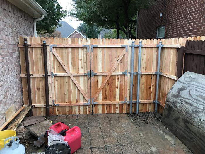 New cedar privacy fence with double drive gates on steel posts