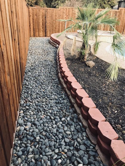 River-rock drainage bed with curved block border